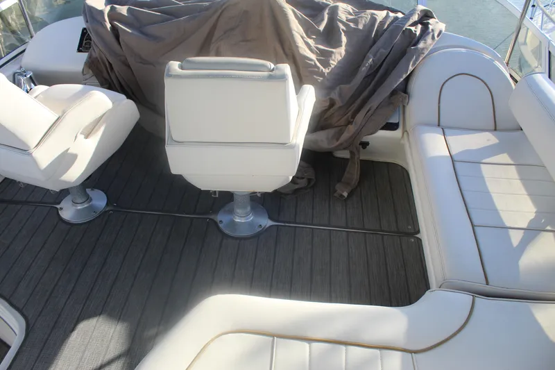 Slide: The Image of 1997 Sea Ray 400 Sedan Bridge interior with white seating and covered controls. - 36