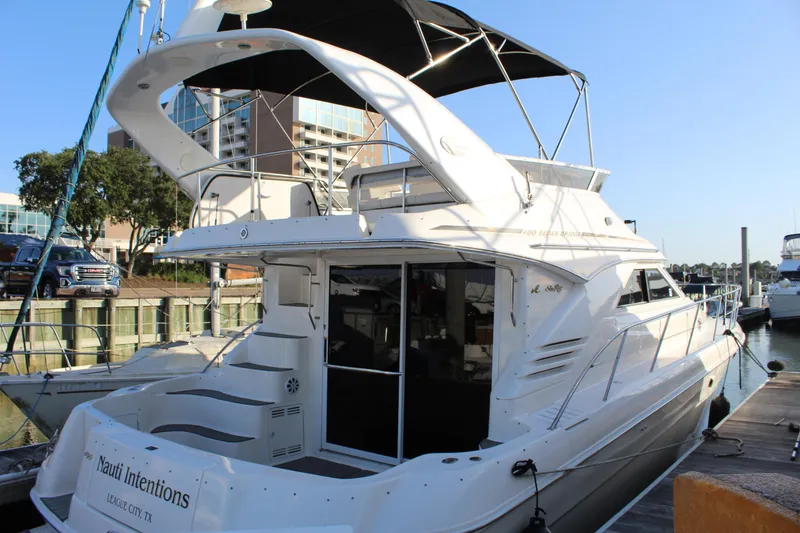 Slide: The Image of 1997 Sea Ray 400 Sedan Bridge yacht docked at marina, featuring sleek design and spacious deck. - 5