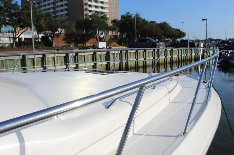 Slide: The Image of 1997 Sea Ray 400 Sedan Bridge yacht docked at marina, with sleek white deck and railing. - 7