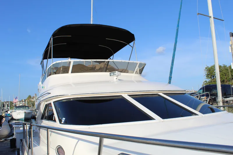 Slide: The Image of 1997 Sea Ray 400 Sedan Bridge yacht docked under clear blue sky. - 8
