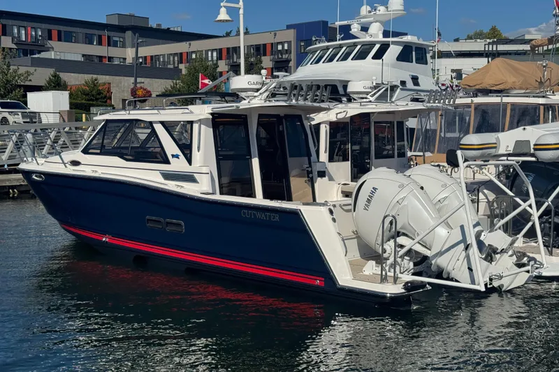 The Image of 2026 Cutwater C-288 Coupe boat docked with Yamaha engines, modern marina backdrop. - 0
