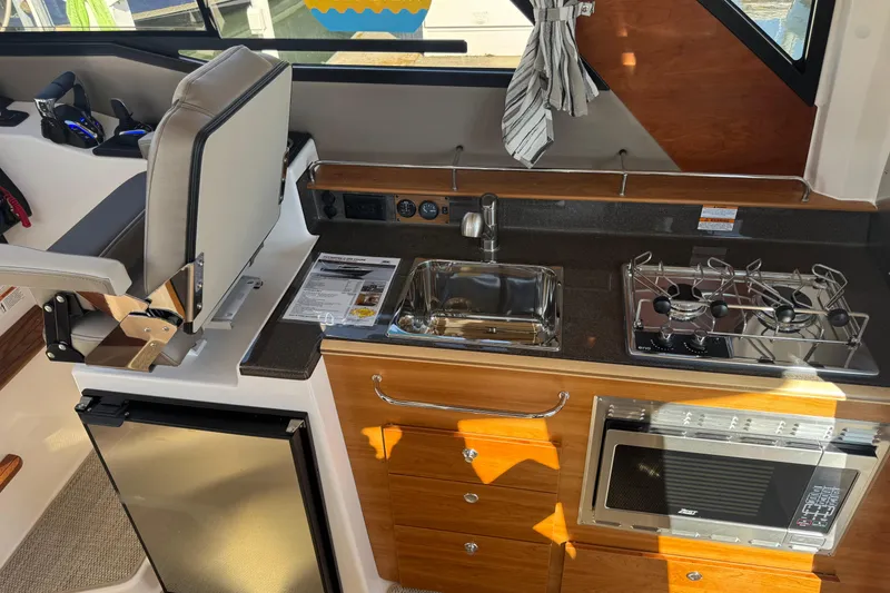 Slide: The Image of Interior of 2026 Cutwater C-288 Coupe featuring kitchen with sink, stove, and microwave. - 10