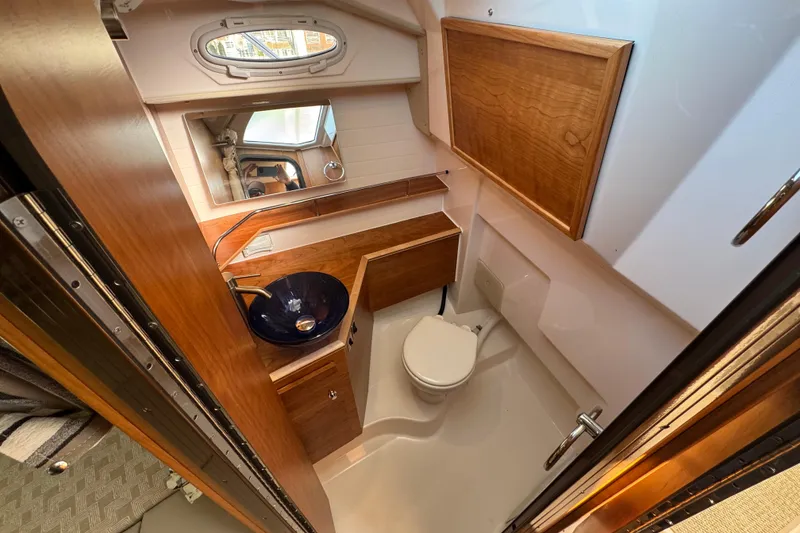 Slide: The Image of 2026 Cutwater C-288 Coupe bathroom with wooden cabinetry and modern fixtures. - 15