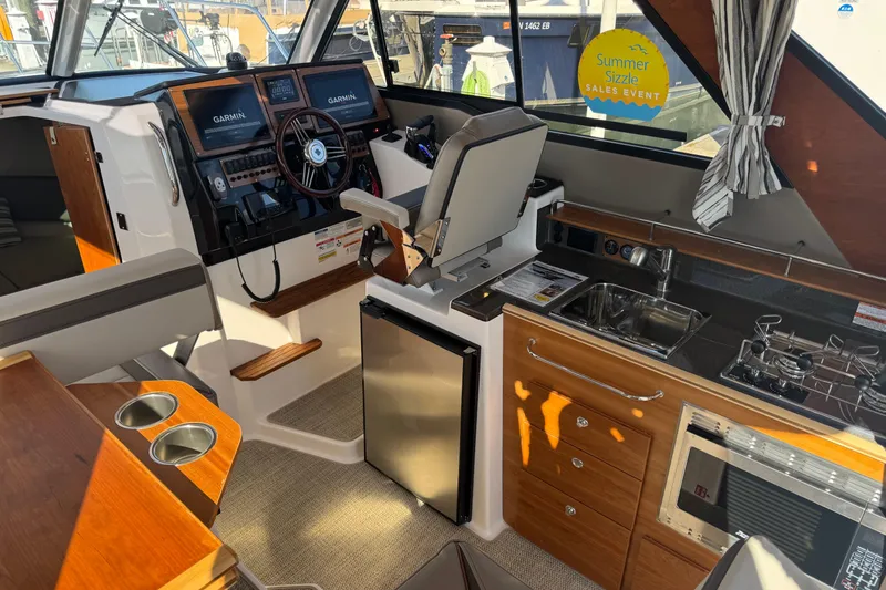 Slide: The Image of Interior of 2026 Cutwater C-288 Coupe featuring helm, kitchen, and navigation equipment. - 9
