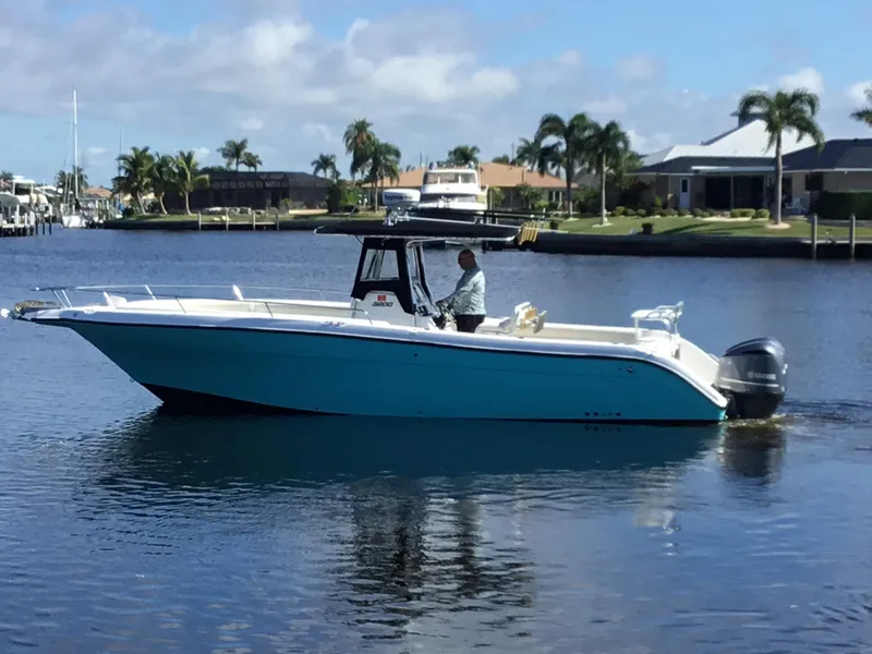 Slide: The Image of 2004 Century 3200 Center Console boat on calm water, with palm trees in the background. - 1