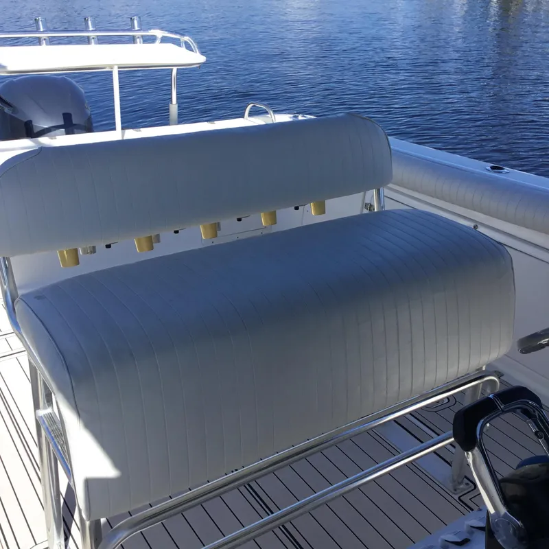 Slide: The Image of 2004 Century 3200 Center Console boat with cushioned seating and rod holders on deck. - 27