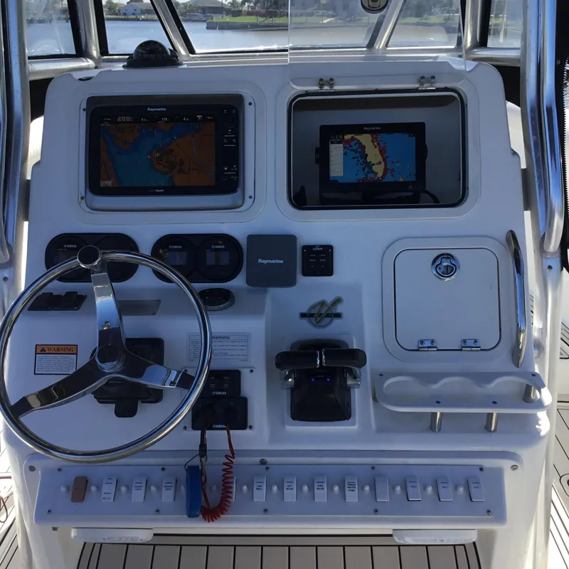 Slide: The Image of 2004 Century 3200 Center Console boat dashboard with navigation screens and steering wheel. - 29