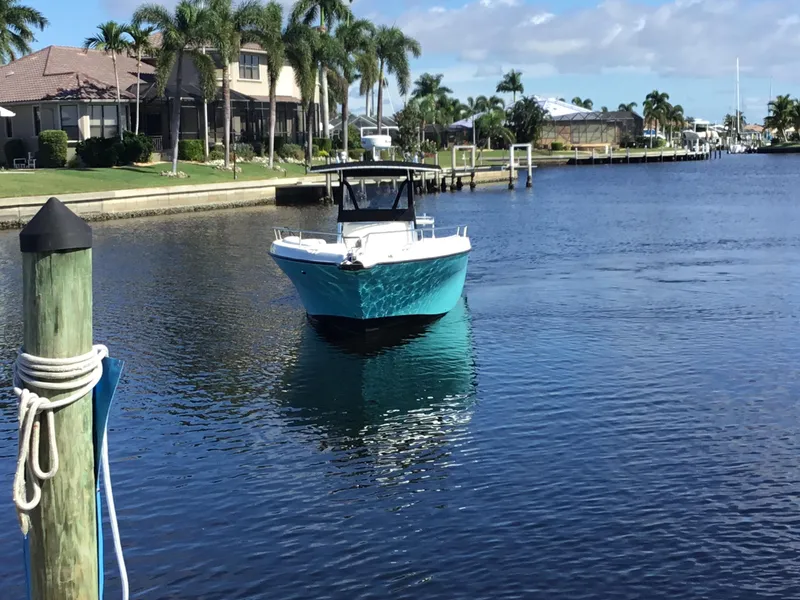 Slide: The Image of 2004 Century 3200 Center Console boat on a calm canal with palm trees. - 3
