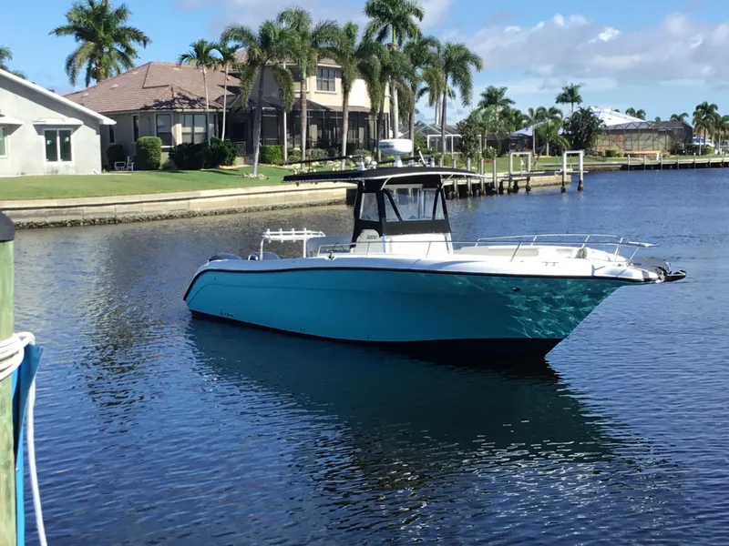 Slide: The Image of 2004 Century 3200 Center Console boat on calm water, surrounded by palm trees and houses. - 4