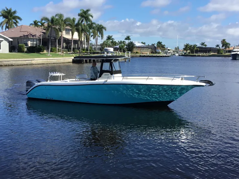 Slide: The Image of 2004 Century 3200 Center Console boat on calm water, surrounded by palm trees and houses. - 5