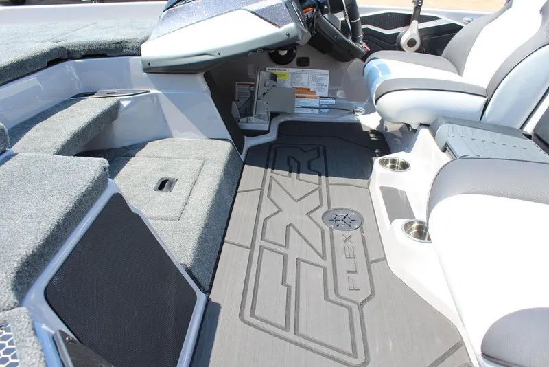 Slide: The Image of 2026 Skeeter FXR20 FLEX boat deck with fishing equipment, parked outdoors. - 15