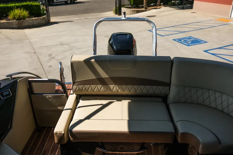 Slide: The Image of 2018 Crest Savannah 250 SLS boat interior with beige seating and outdoor view. - 11