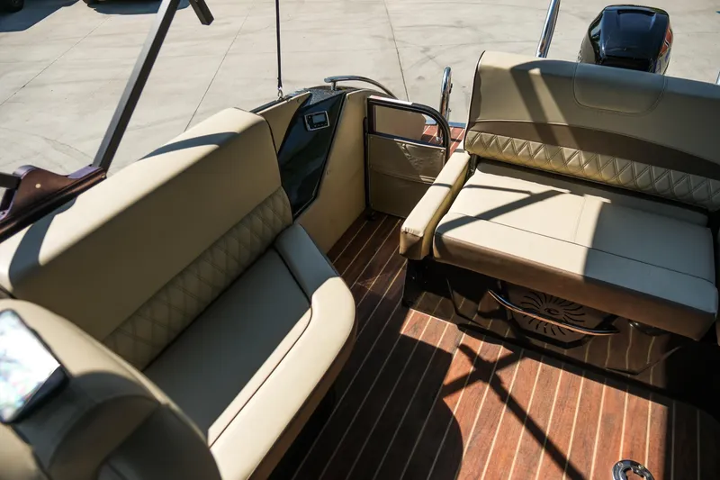 Slide: The Image of 2018 Crest Savannah 250 SLS boat interior with beige seating and wood flooring. - 12