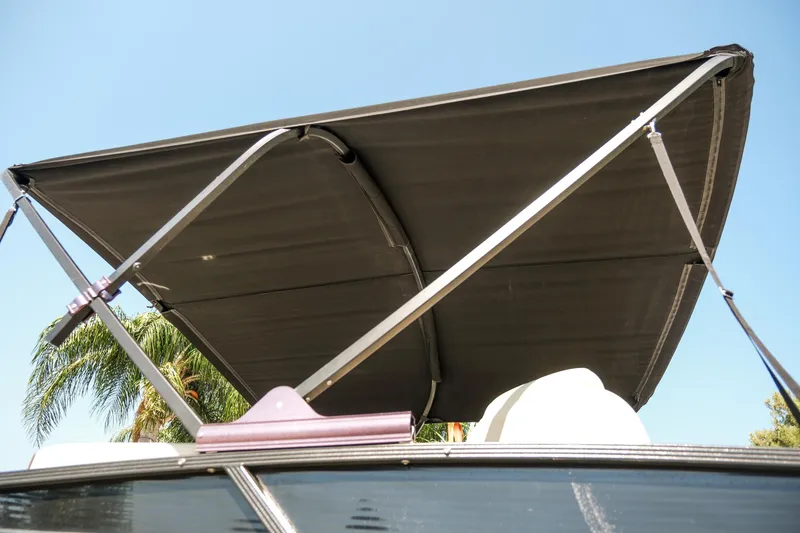Slide: The Image of 2018 Crest Savannah 250 SLS boat canopy against blue sky and palm trees. - 22