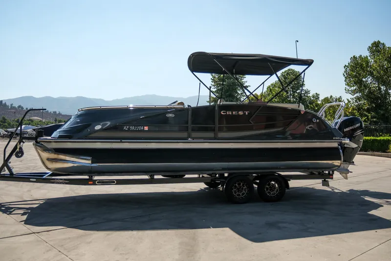 Slide: The Image of 2018 Crest Savannah 250 SLS pontoon boat on trailer, parked outdoors. - 3
