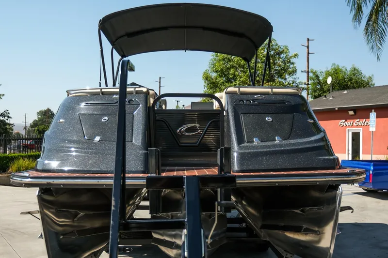 Slide: The Image of 2018 Crest Savannah 250 SLS pontoon boat, rear view, parked outdoors. - 5
