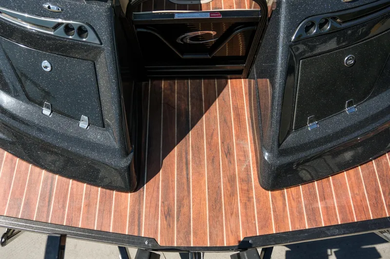 Slide: The Image of 2018 Crest Savannah 250 SLS boat deck with sleek black panels and wood finish. - 6