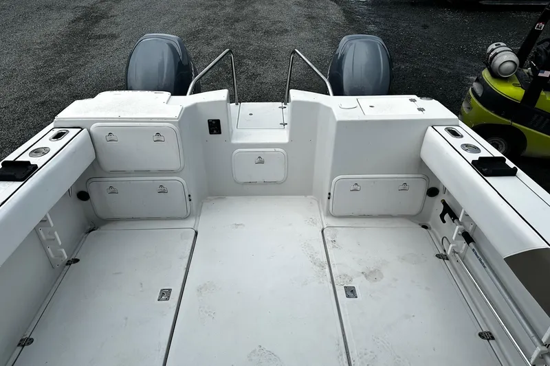 Slide: The Image of 2006 Glacier Bay 2670 boat seat with white and brown upholstery, docked in a marina. - 13
