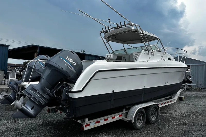 Slide: The Image of 2006 Glacier Bay 2670 boat on trailer with Yamaha engines, parked outdoors. - 2