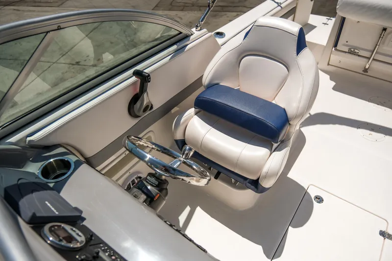 Slide: The Image of 2021 Robalo R227 Dual Console boat interior with steering wheel and captain's seat. - 14