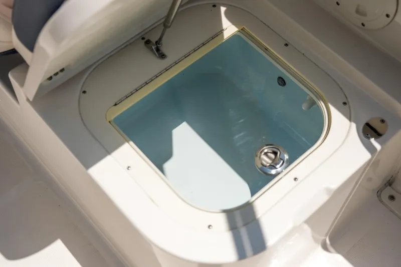 Slide: The Image of 2021 Robalo R227 Dual Console livewell with open lid, showcasing interior details. - 18