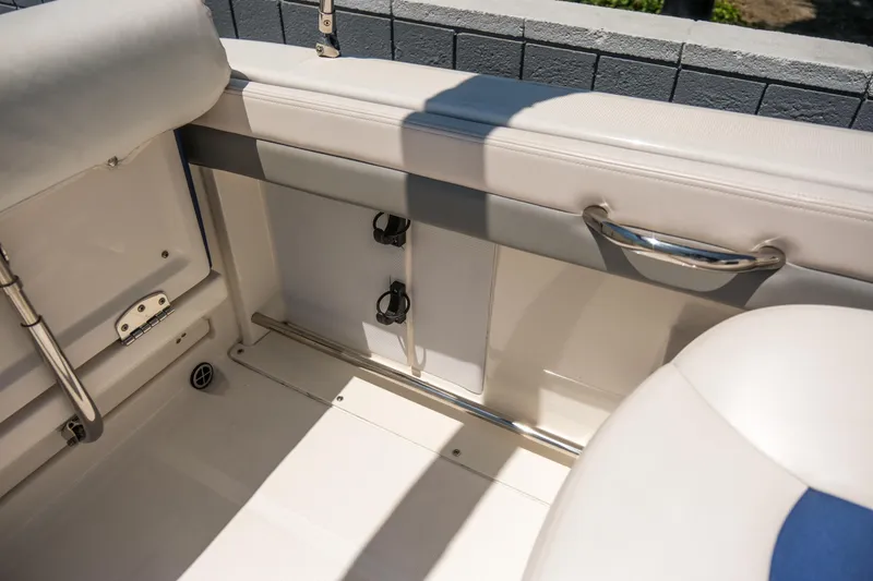 Slide: The Image of 2021 Robalo R227 Dual Console interior with beige seating and stainless steel accents. - 24