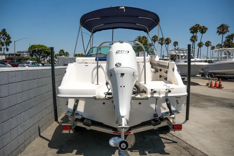 Slide: The Image of 2021 Robalo R227 Dual Console boat with outboard motor, parked in marina. - 28