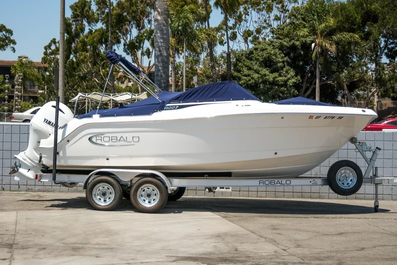 Slide: The Image of 2021 Robalo R227 Dual Console boat on trailer, parked outdoors. - 4