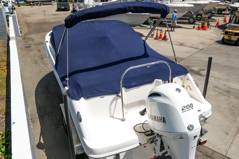 Slide: The Image of 2021 Robalo R227 Dual Console boat with Yamaha 200 engine, covered and docked. - 5