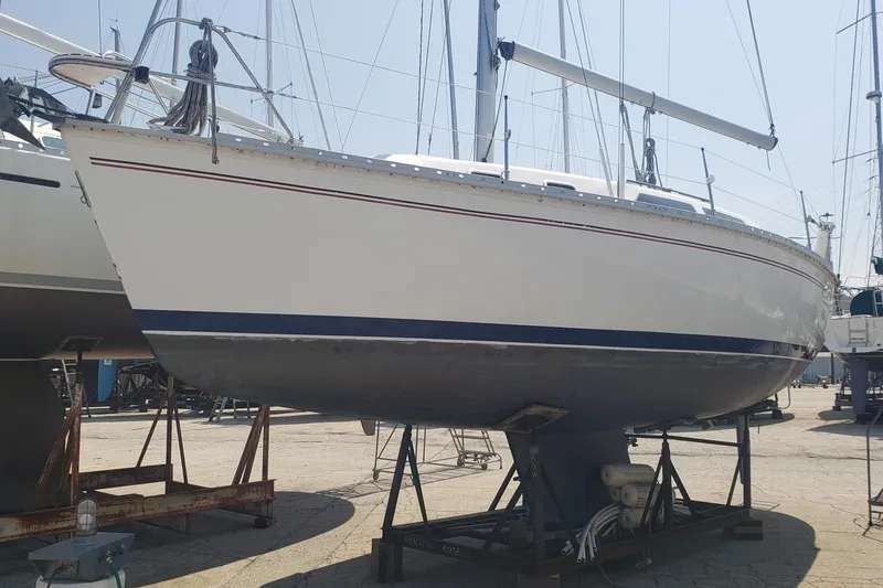 The Image of 1994 Hunter 30 sailboat on stands in a boatyard, side view. - 0