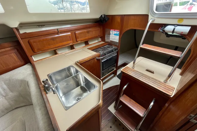 Slide: The Image of Interior of a 1994 Hunter 30 sailboat featuring a compact kitchen with dual sinks. - 12