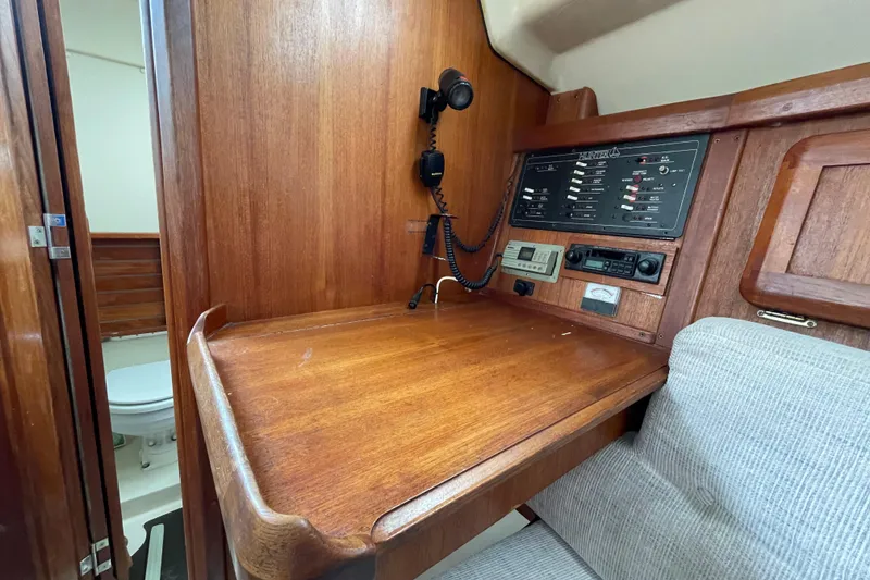 Slide: The Image of 1994 Hunter 30 yacht interior with wooden navigation station and control panel. - 16