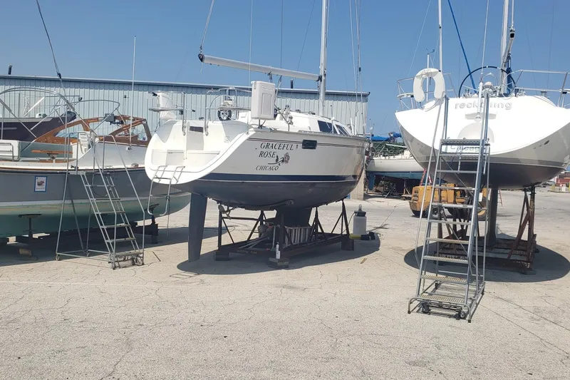 Slide: The Image of 1994 Hunter 30 sailboat on stands in a boatyard, surrounded by other vessels. - 4