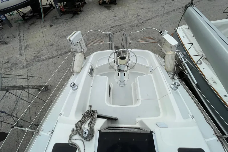 Slide: The Image of Cockpit view of a 1994 Hunter 30 sailboat, docked with visible steering wheel. - 9