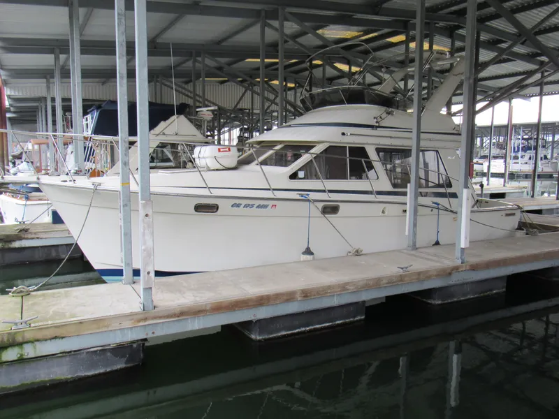 The Image of 1989 Tollycraft Sport Sedan docked in a covered marina. - 0