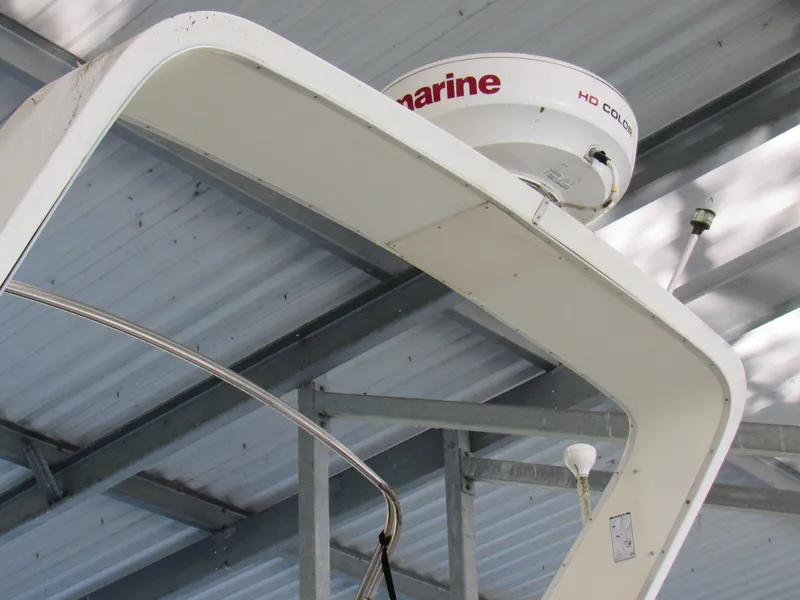 Slide: The Image of 1989 Tollycraft Sport Sedan radar arch with marine equipment under a metal roof. - 13