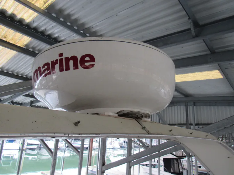 Slide: The Image of 1989 Tollycraft Sport Sedan radar dome under metal roof in marina. - 14