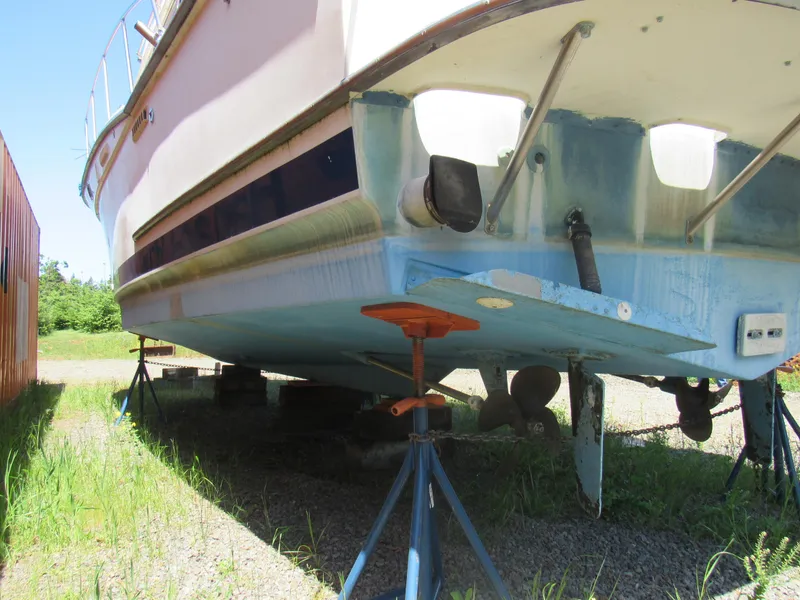 Slide: The Image of 1989 Tollycraft Sport Sedan boat on stands, showing hull and propeller. - 19