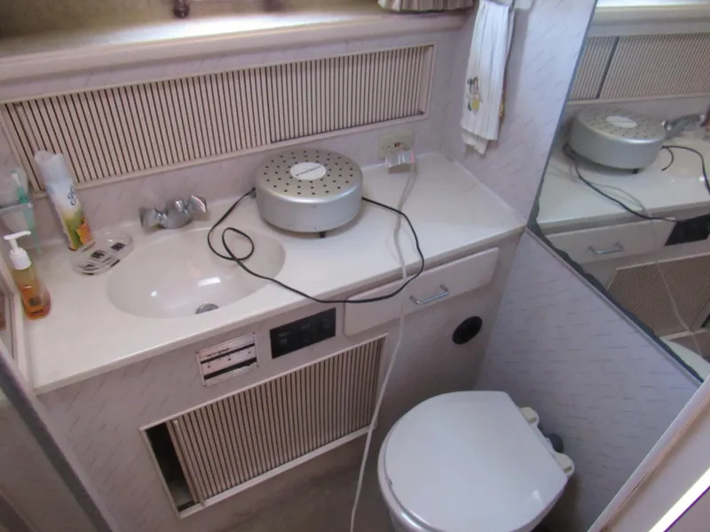 Slide: The Image of 1989 Tollycraft Sport Sedan bathroom with sink, toilet, and countertop accessories. - 27
