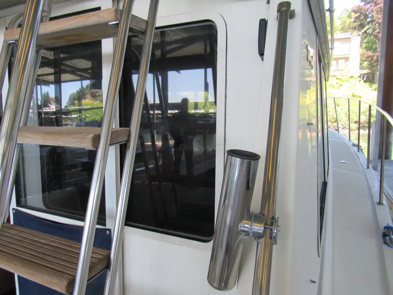 Slide: The Image of 1989 Tollycraft Sport Sedan boat with ladder and window, docked outdoors. - 3