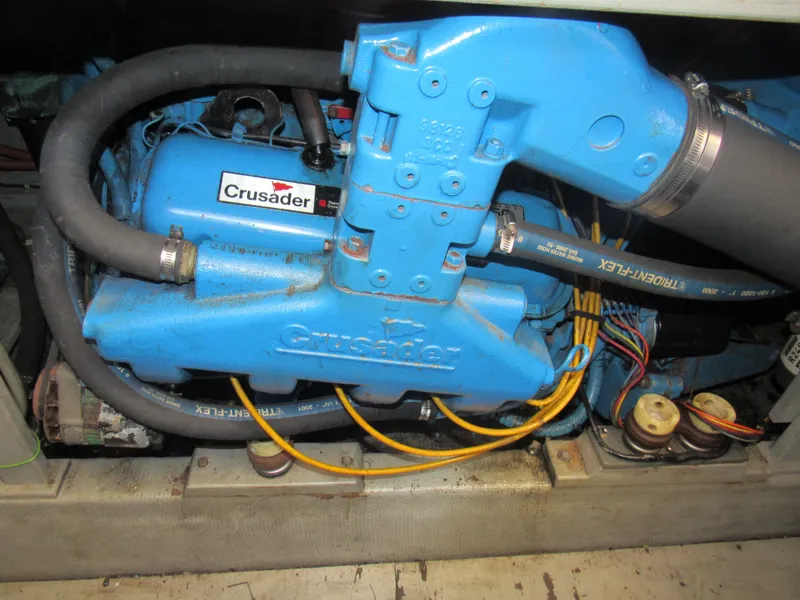 Slide: The Image of 1989 Tollycraft Sport Sedan engine, featuring a blue Crusader motor with visible hoses and wiring. - 35