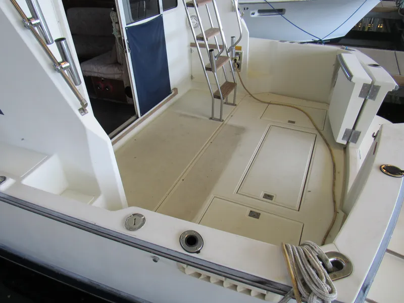 Slide: The Image of 1989 Tollycraft Sport Sedan boat deck with ladder and storage compartments. - 4