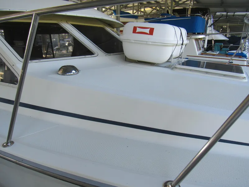 Slide: The Image of 1989 Tollycraft Sport Sedan boat with life raft on deck, docked in marina. - 5