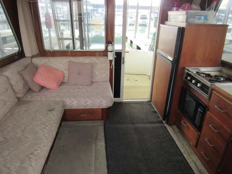 Slide: The Image of 1989 Tollycraft Sport Sedan interior with cozy seating, kitchen, and outdoor view. - 6