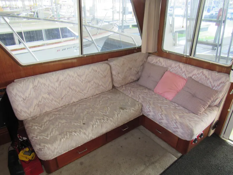 Slide: The Image of 1989 Tollycraft Sport Sedan interior with patterned seating and cushions, featuring large windows. - 7