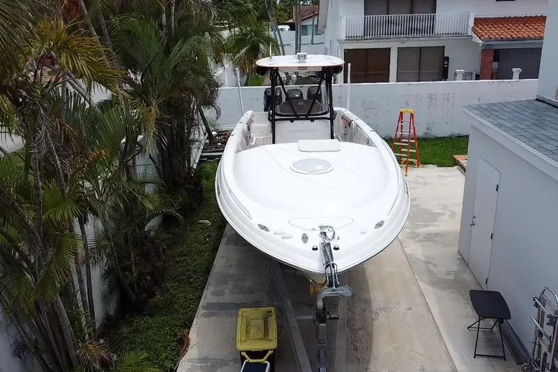Slide: The Image of 2007 Scarab 35 Sport boat parked with a person nearby, surrounded by palm trees. - 10
