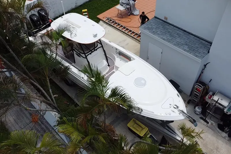 Slide: The Image of 2007 Scarab 35 Sport boat, white exterior, parked on trailer, residential background. - 12