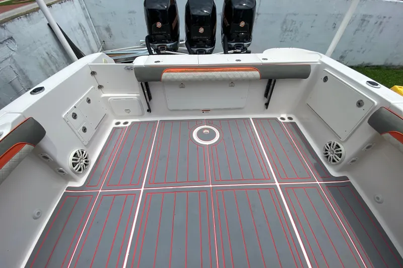 Slide: The Image of 2007 Scarab 35 Sport boat deck with gray and red flooring, triple outboard engines. - 18