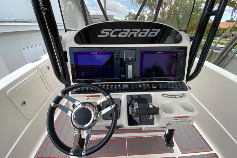 Slide: The Image of 2007 Scarab 35 Sport boat dashboard with dual Simrad displays and steering wheel. - 24