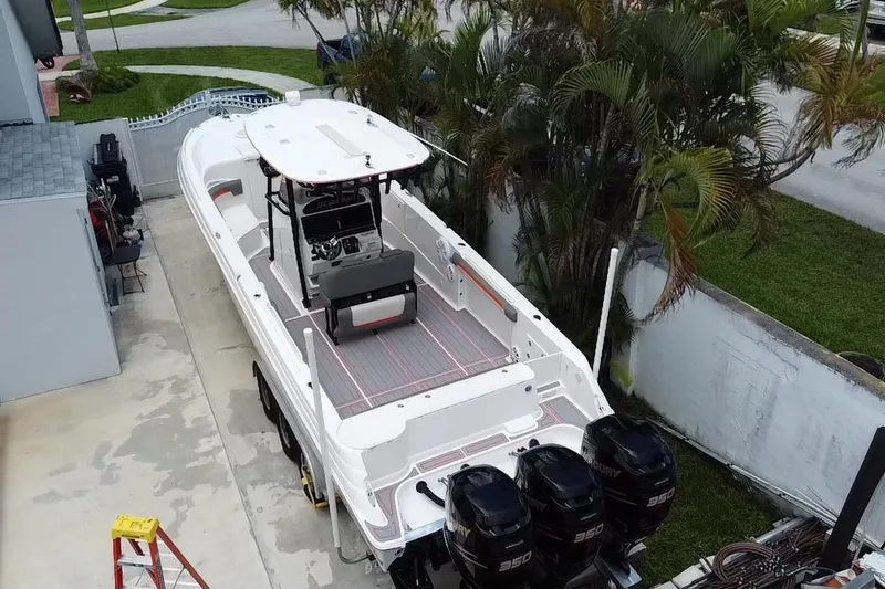 Slide: The Image of 2007 Scarab 35 Sport boat with triple Mercury 350 engines, parked beside a house. - 32